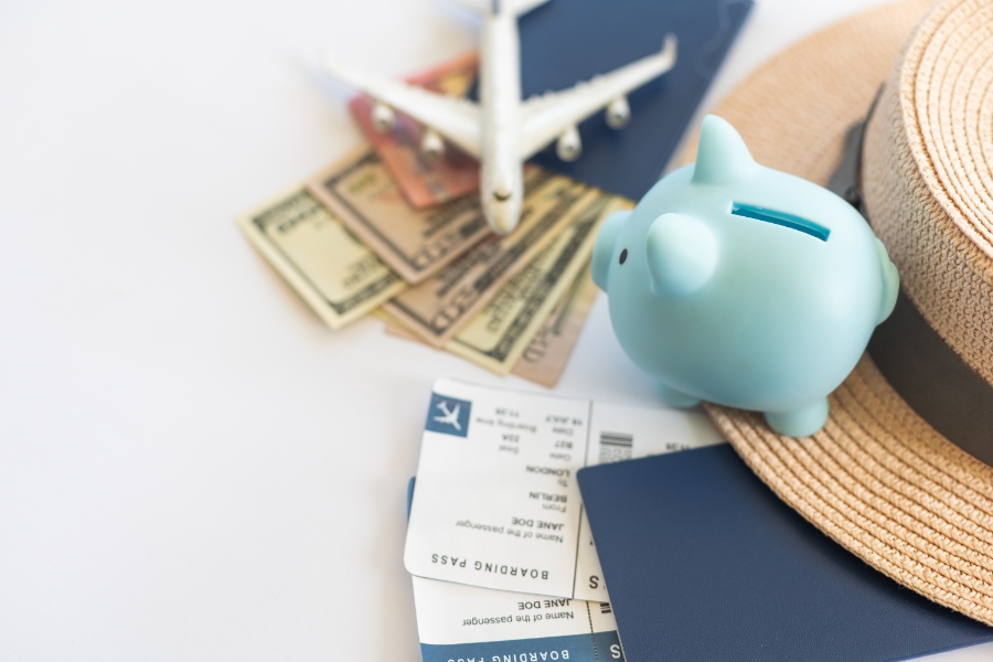 Planning a Trip to Germany: Step-by-Step Guide for First-Timers 17 Airplane model and piggy bank on a wooden table, symbolizing saving for travel expenses and budgeting for airplane tickets.