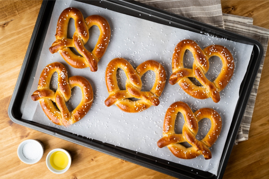 German Bread Culture: Bakeries, Loaves and Traditions 17 Freshly baked pretzels displayed on a wooden table, showcasing their golden crust and twisted shape.