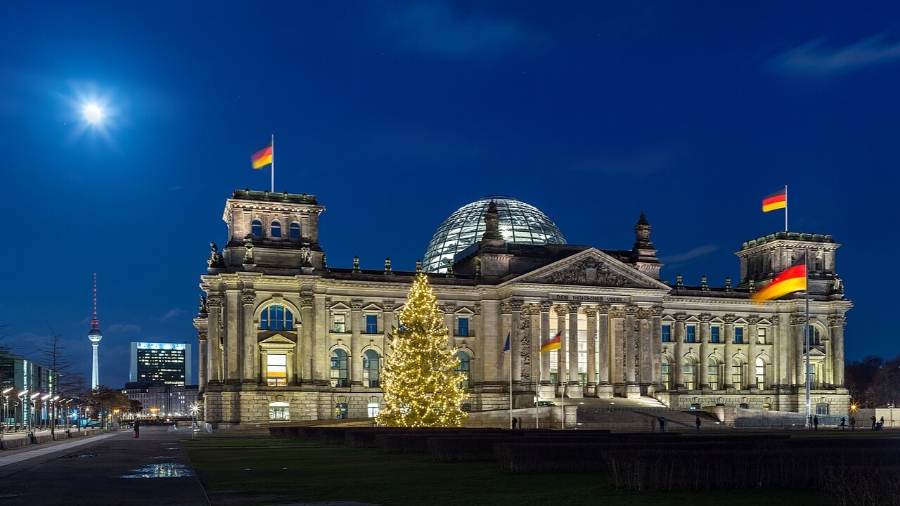 German Christmas Traditions: A Complete Guide 36 The Reichstag building in Berlin, Germany, adorned with festive Christmas lights and decorations during the holiday season.