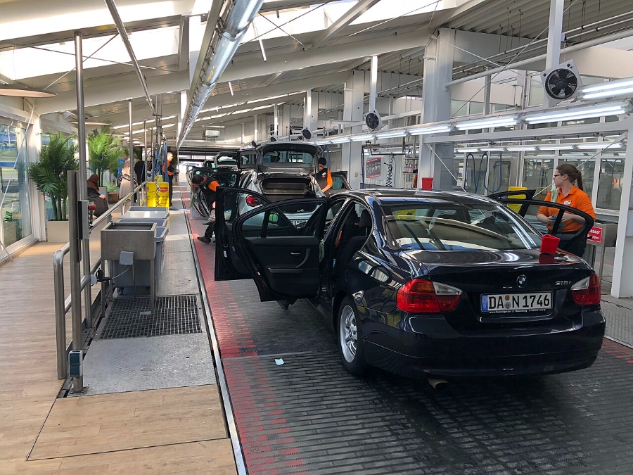 Sunday & Quiet Hours in Germany: The Complete Survival Guide 15 Inside a factory, a technician is servicing a car, surrounded by tools and machinery.
