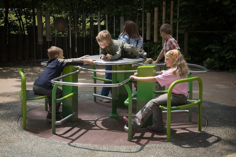 Sunday & Quiet Hours in Germany: The Complete Survival Guide 16 Children playing joyfully on a playground in Munich, surrounded by green chairs and vibrant outdoor scenery.