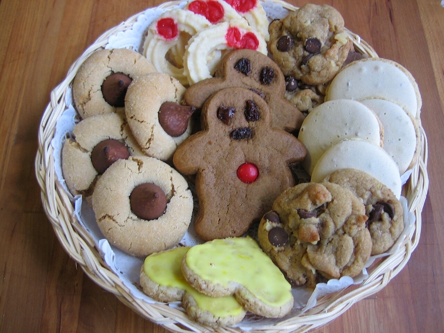 German Christmas Traditions: A Complete Guide 32 Close-up of a basket filled with various decorated Christmas cookies on a wooden table.