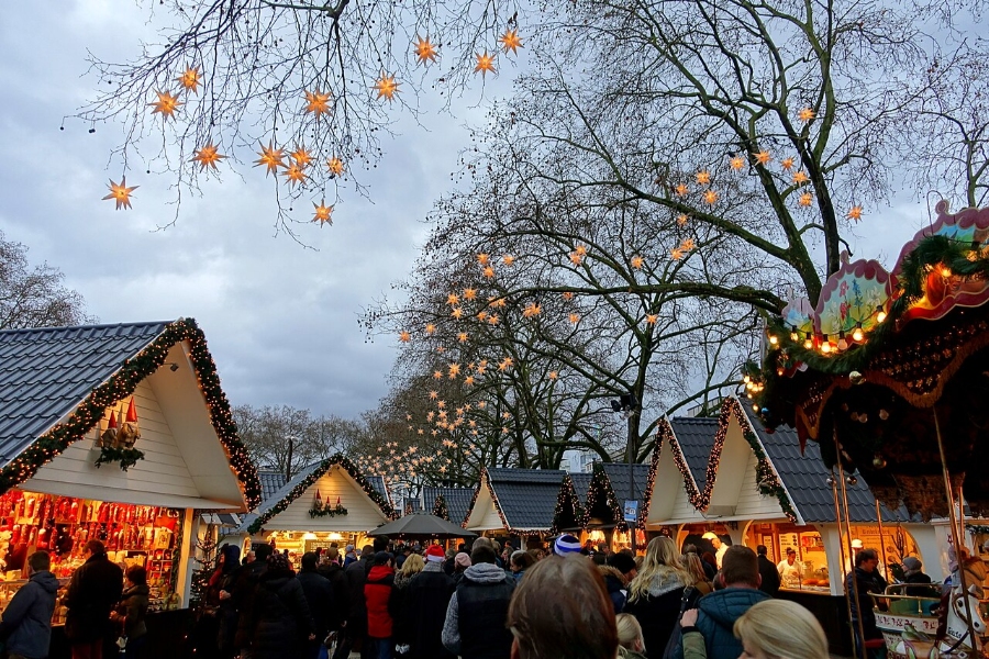German Christmas Traditions: A Complete Guide 28 Cologne's Christmas market showcasing vibrant stalls, holiday lights, and visitors enjoying seasonal treats and festive atmosphere.