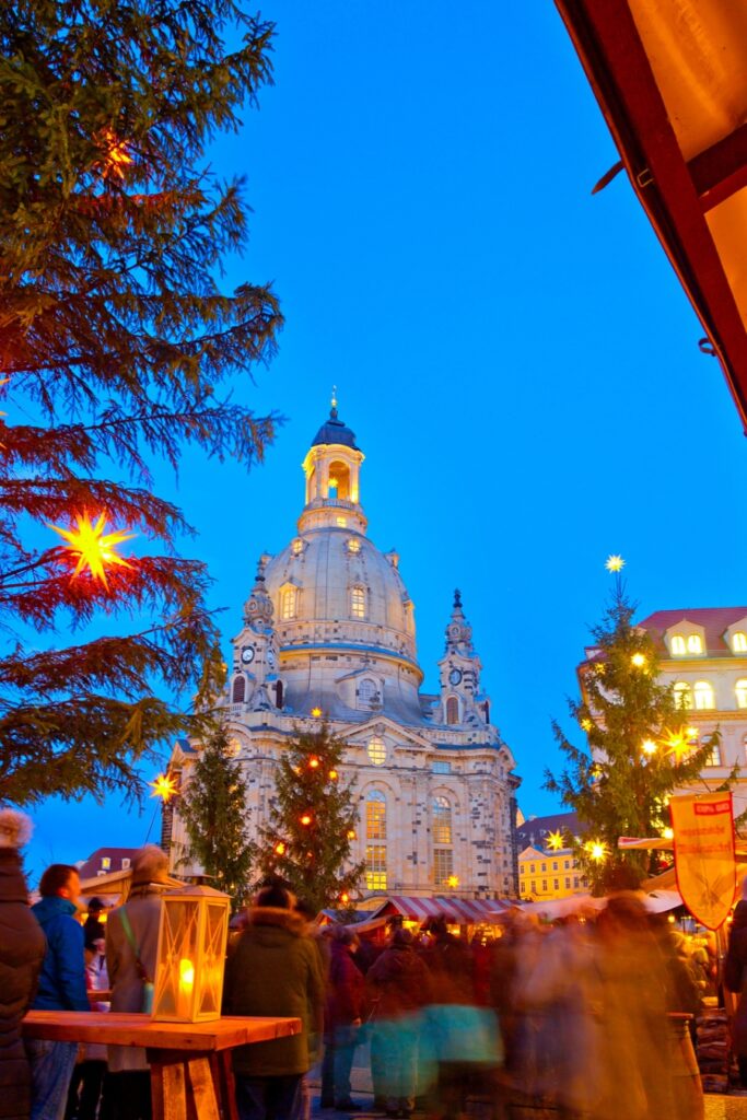 The Ultimate Guide to German Christmas Markets 4 The clock tower of a grand building, beautifully decorated for the Dresden Christmas Market, surrounded by holiday festivities.