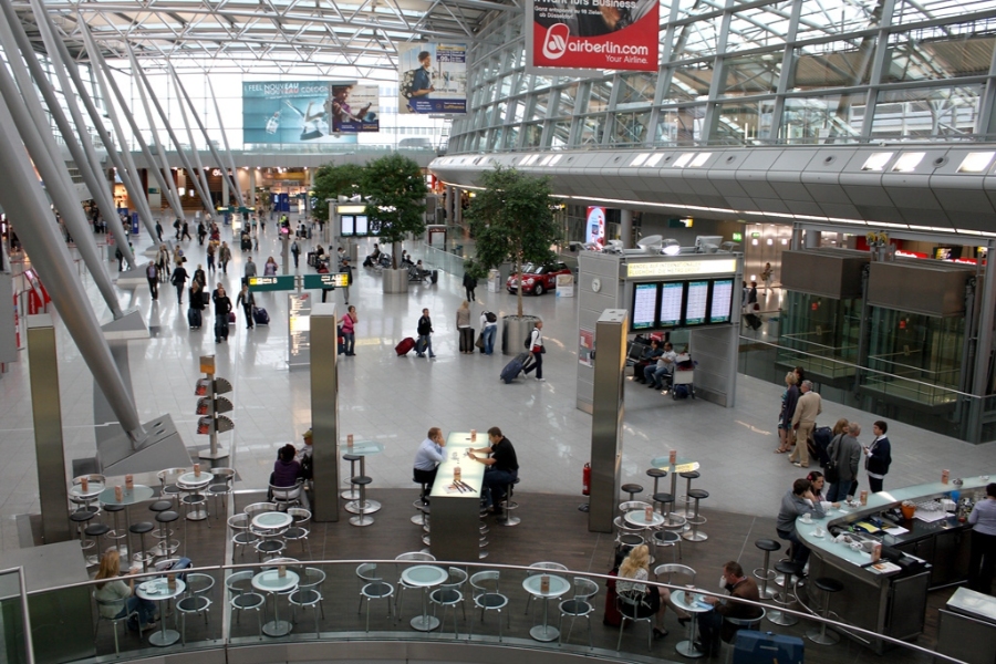 Düsseldorf Airport 13 The interior of Düsseldorf Airport terminal, showcasing sleek design and numerous passengers navigating the space.