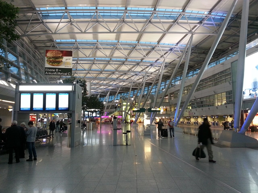 Düsseldorf Airport 2 Interior view of Düsseldorf Airport terminal, showcasing numerous passengers navigating through the space.