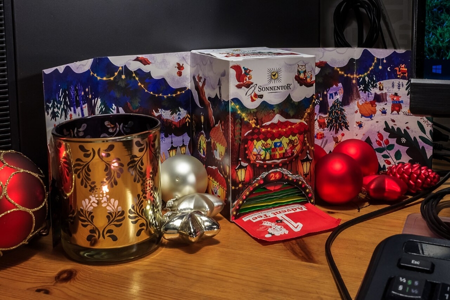 German Christmas Traditions: A Complete Guide 7 Workspace with a computer, a holiday card, and a candle, evoking the spirit of Christmas and Advent celebrations.