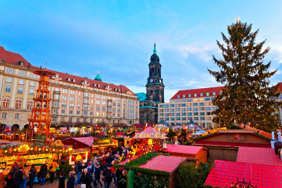 The Ultimate Guide to German Christmas Markets 3 Christmas market in Dresden, Germany, featuring festive lights, stalls, and visitors enjoying seasonal treats.