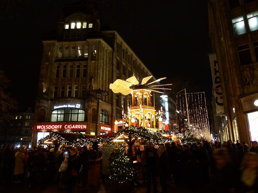 German Christmas Traditions: A Complete Guide 20 Nighttime scene of a crowded street in Hamburg, Germany, filled with people visiting a vibrant Christmas market.