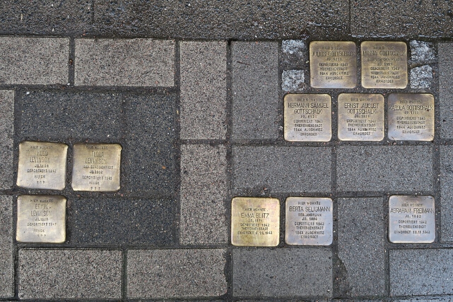 Close-up of gold Stolpersteine plaques on a sidewalk, honoring Holocaust victims in Hamburg, Germany.

