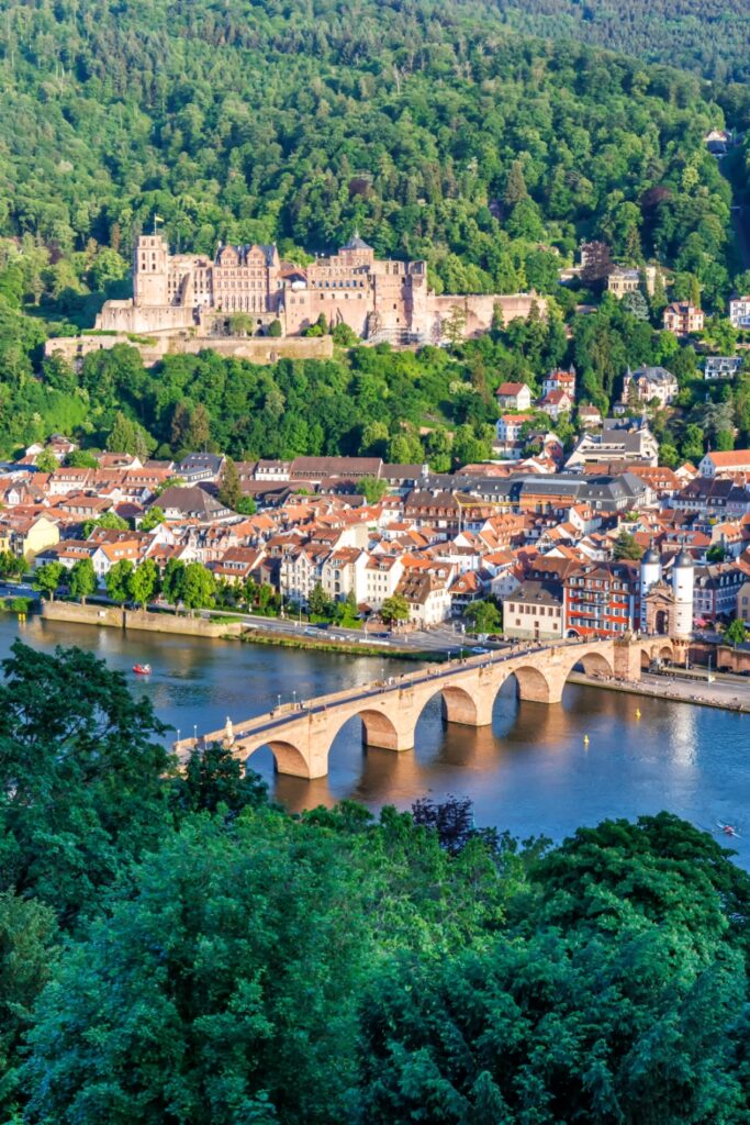 Exploring the German Castle Road: A Complete Guide 14 Scenic view of Heidelberg Castle, Neckar River, and the old bridge in portrait format, showcasing the beauty of Heidelberg, Germany.