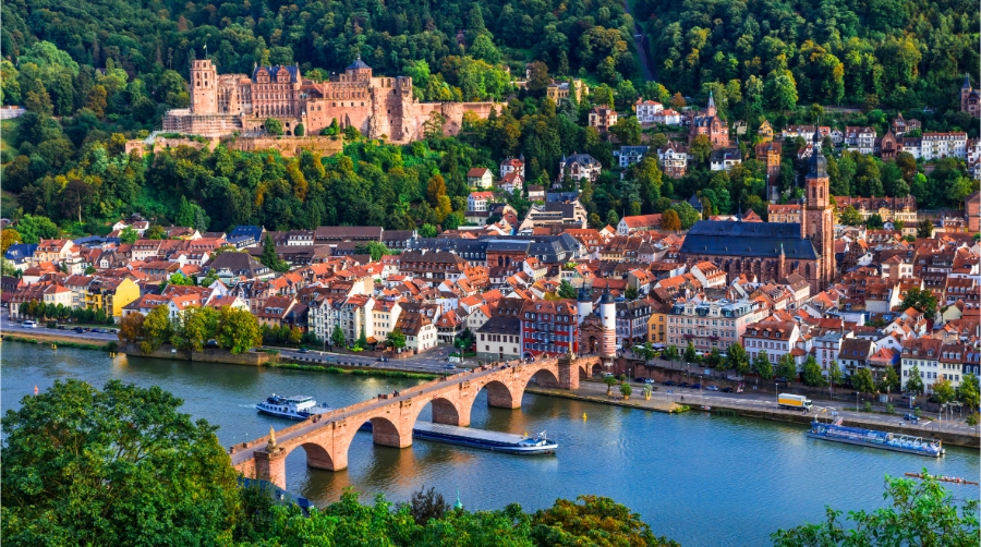 Planning a Trip to Germany: Step-by-Step Guide for First-Timers 11 Panoramic view of Heidelberg featuring Karl Theodor Bridge and historic Castle over the Neckar River in Baden-Württemberg, Germany.
