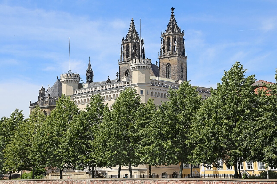 Magdeburg Cathedral featuring two prominent towers and intricate architectural details against a clear sky.
