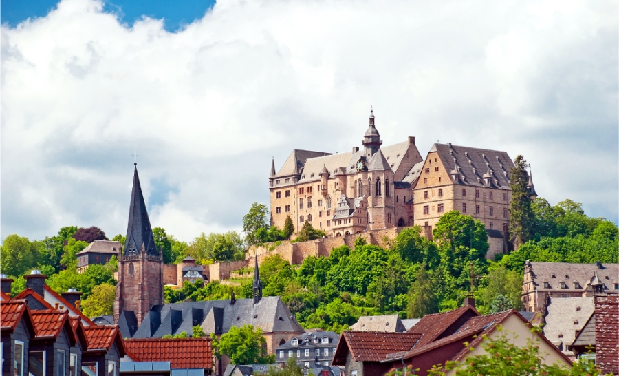 Sunday & Quiet Hours in Germany: The Complete Survival Guide 3 Aerial view of Marburg Castle on a hill, dominating the skyline of the old town in Hesse, Germany, with numerous structures below.
