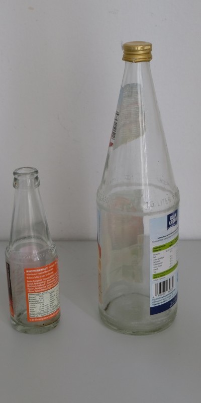 Pfand System Explained: Germany's Bottle Deposit Complete Guide 8 Two empty reusable bottles placed side by side on a flat surface.