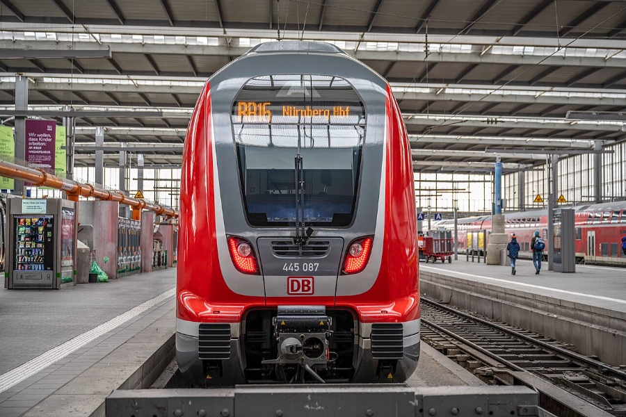 German Regional Day Tickets: Decision Trees for Maximum Savings 17 Red and white train awaits at Munich Central Station, showcasing its vibrant colors against the station backdrop.