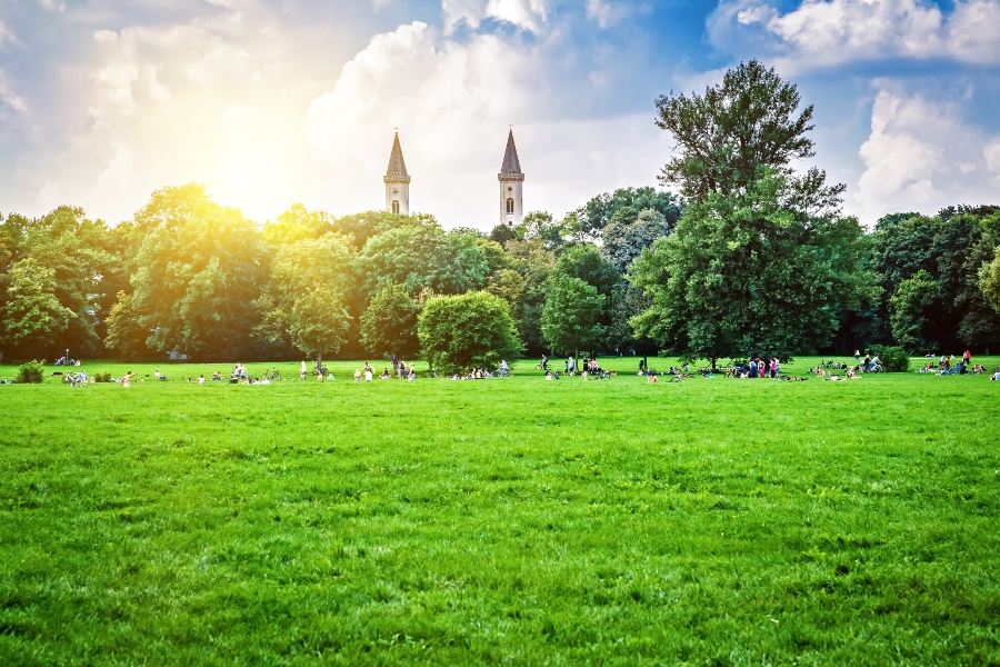 Visiting Germany with Kids: Family-Friendly Destinations & Tips 3 Scenic view of an English garden in Munich, showcasing colorful blooms, green hedges, and tranquil pathways.