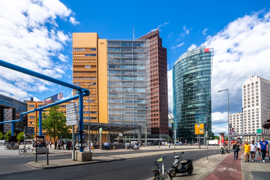 Planning a Trip to Germany: Step-by-Step Guide for First-Timers 37 Potsdamer Platz in Berlin, showcasing a lively street scene with modern skyscrapers and people walking amidst urban activity.