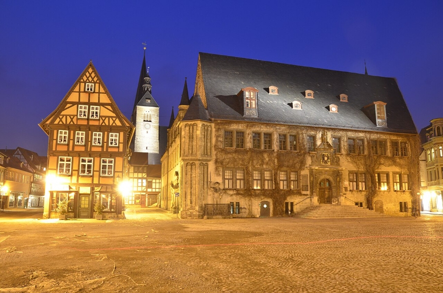 German Half-Timbered Route: Complete 7-Day Itinerary 15 Night view of Quedlinburg's town square featuring a historic clock tower illuminated against the dark sky.