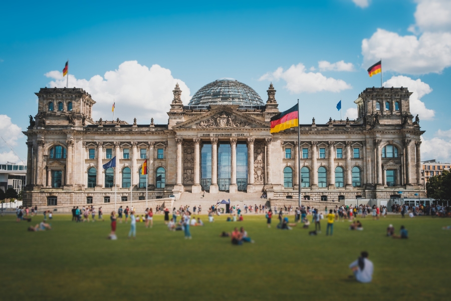 Germany Travel Guide: Ultimate Resource for Destinations, Culture & Tips 28 The Reichstag Building stands prominently amidst a bustling city street filled with pedestrians and tall buildings.