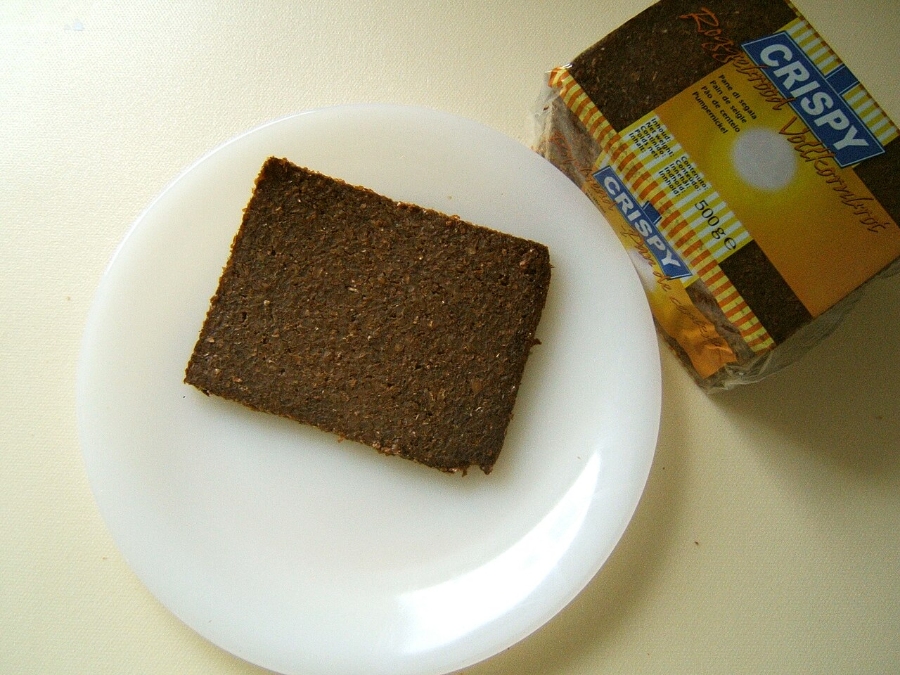 German Bread Culture: Bakeries, Loaves and Traditions 11 Piece of Roggenbrot, showcasing its dense texture and dark crust, served on a simple plate.