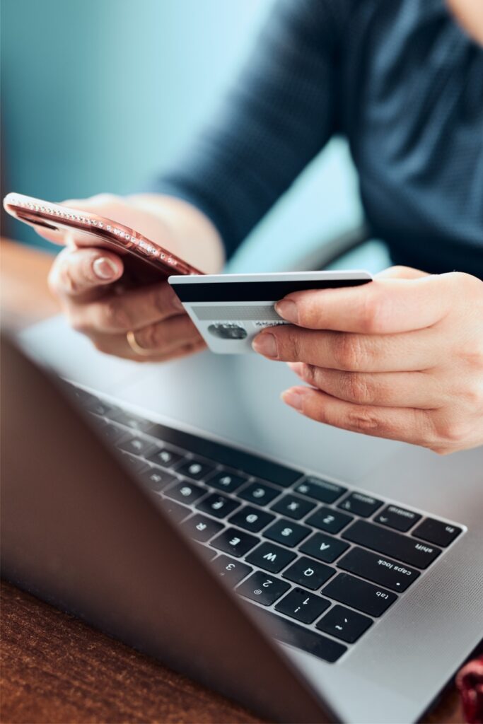 German Regional Day Tickets: Decision Trees for Maximum Savings 18 Woman shopping online, holding a debit card over a laptop keyboard while seated at a desk in her home.