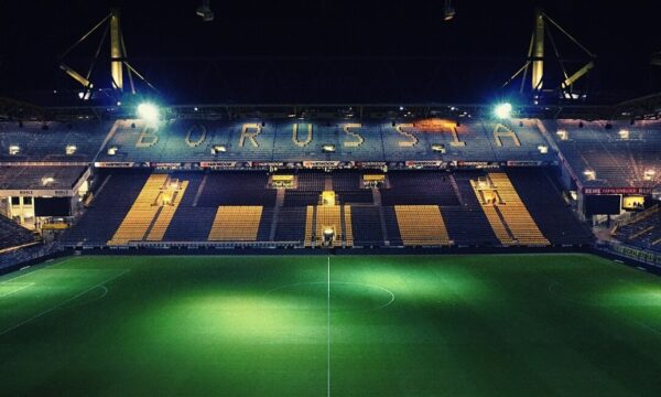 Signal Iduna Park illuminated at night, showcasing its vibrant lights and the grandeur of the soccer stadium in Dortmund, Germany.