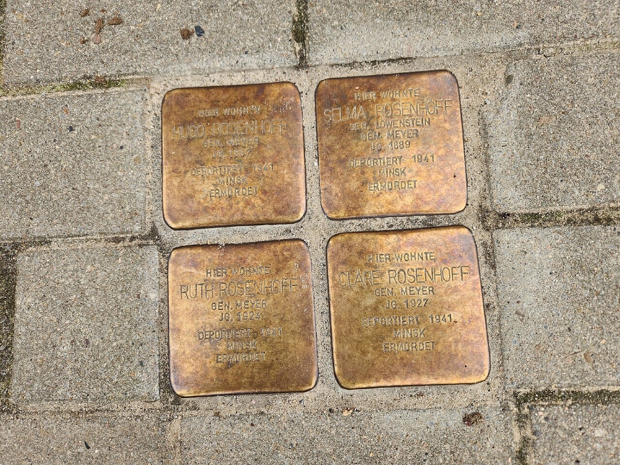 Four bronze Stolpersteine plaques embedded in a sidewalk in Osterholz-Scharmbeck, Germany, commemorating Holocaust victims.
