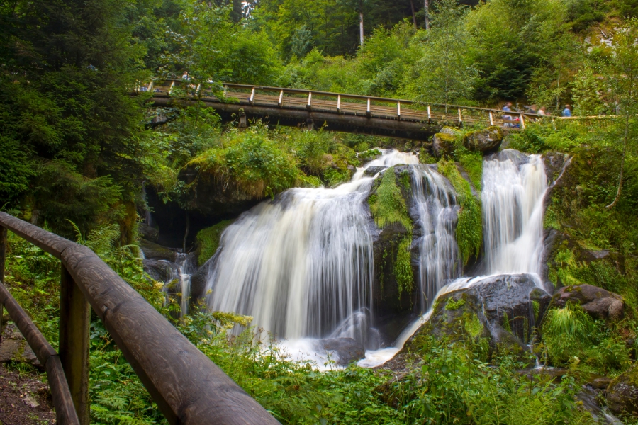 15 Best Places to Visit in Germany for an Unforgettable Trip 8 Triberg Waterfalls cascades through the Black Forest, with a wooden bridge crossing over the flowing water.