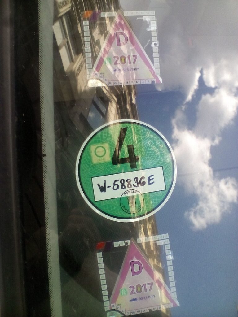 Umweltzone Guide: Germany's Low-Emission Zones Explained for Tourists 10 Car window displaying Umweltplakette stickers with the numbers "4" and "4" prominently visible.