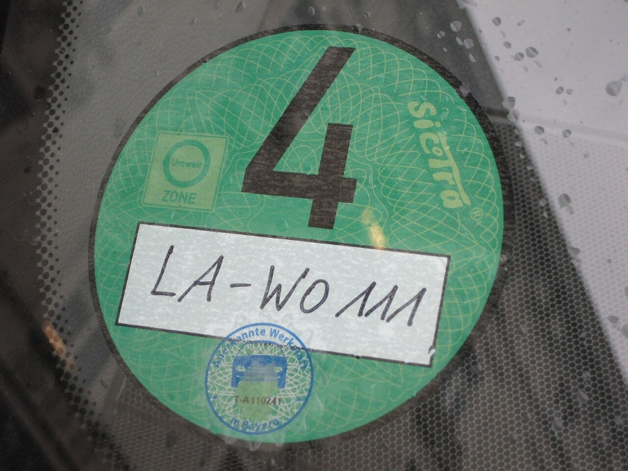 Umweltzone Guide: Germany's Low-Emission Zones Explained for Tourists 8 Car window displays a green Umweltplakette sticker marked with the number 4, indicating environmental compliance.