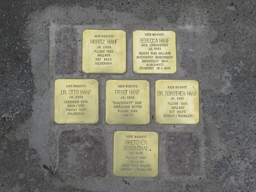 Six gold Stolpersteine plaques on the ground in Witten, Germany, honoring the memory of Holocaust victims.
