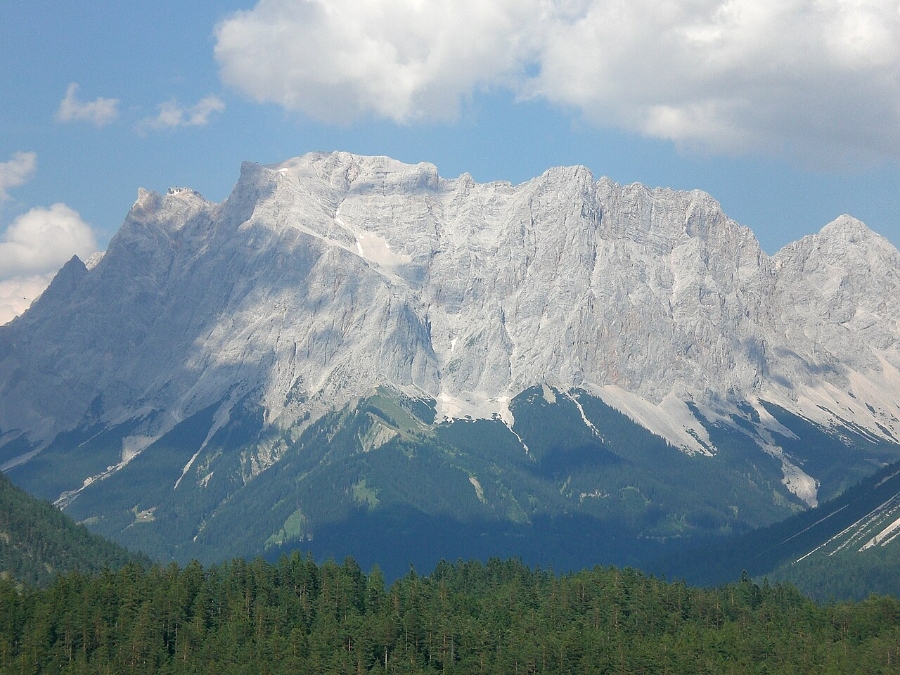 Zugspitze 18 Scenic view of Zugspitze Schneefernerkopf, showcasing a mountain range with lush trees and towering peaks in the background.