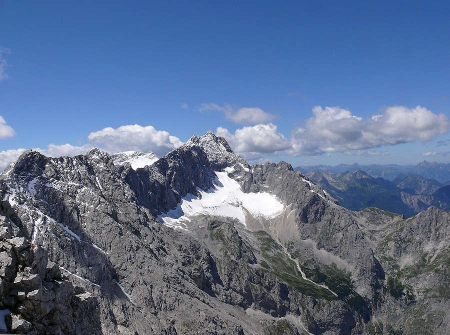 Zugspitze 5 Man on the summit of Zugspitze, overlooking a breathtaking mountain landscape in Bavaria, Germany.