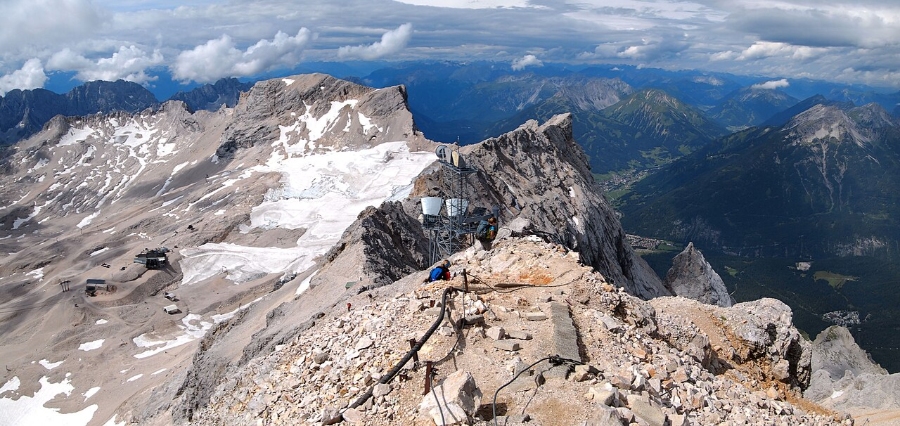 Zugspitze 19 Person at the top of Zugspitze, enjoying panoramic views of the surrounding mountains and valleys.