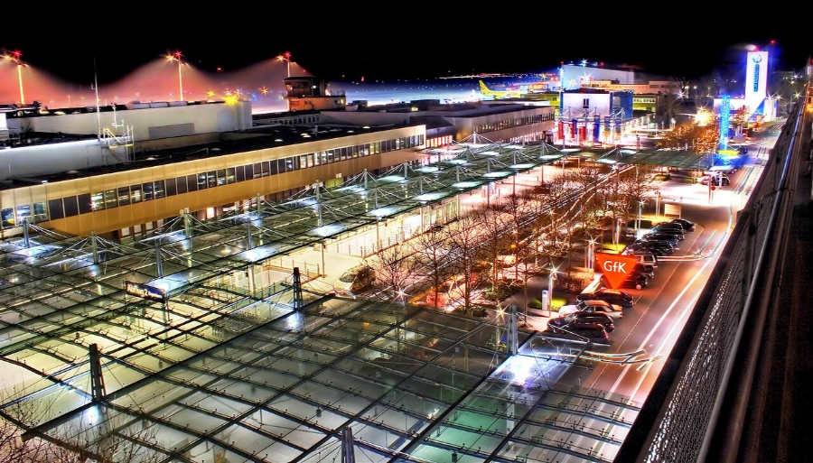 Nuremberg Airport 12 Night view of Nuremberg Airport, Germany, showcasing a large glass roof illuminated against the dark sky.