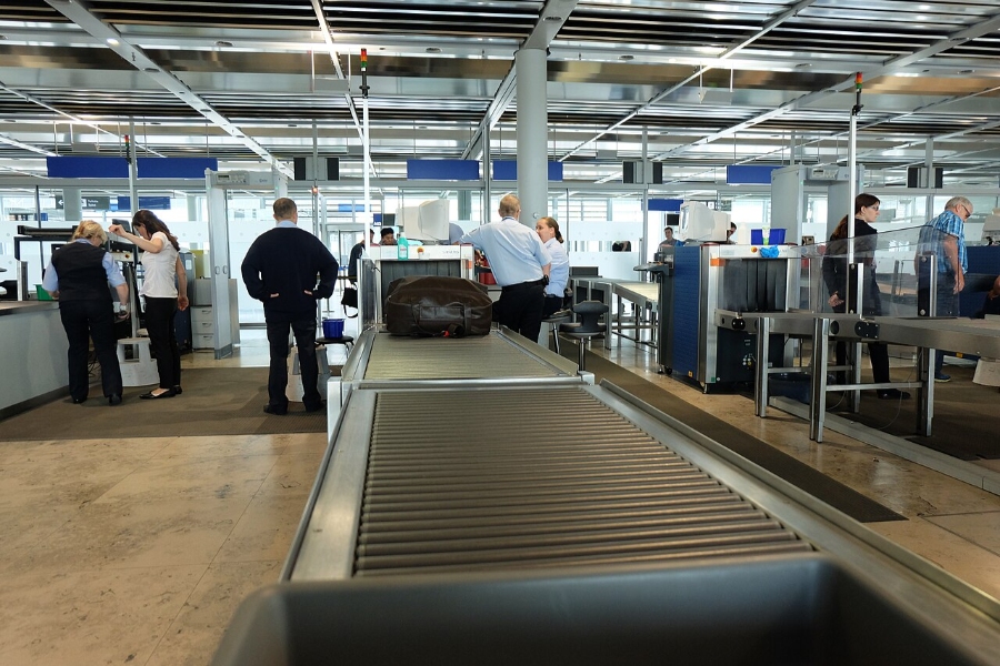 Nuremberg Airport 8 Passengers stand near a baggage claim conveyor belt at Nürnberg Airport, anticipating the arrival of their bags.